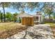 A spacious backyard, featuring a screen porch and an outdoor patio area with trees surrounding at 1232 Sedeeva S Cir, Clearwater, FL 33755