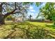 Expansive backyard featuring a lush lawn and privacy fence on a bright, sunny day at 1232 Sedeeva S Cir, Clearwater, FL 33755