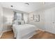 Bright bedroom with a large window, wood floors, and minimalist decor at 1232 Sedeeva S Cir, Clearwater, FL 33755