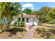 Inviting single story home with a well-manicured lawn, tropical landscaping, and a cozy front entrance at 1232 Sedeeva S Cir, Clearwater, FL 33755