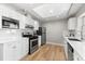 Bright kitchen features stainless steel appliances, white cabinets, and light wood flooring at 1232 Sedeeva S Cir, Clearwater, FL 33755