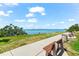 Community water view with bench and walking path, near lush green grass and trees on a clear, sunny day at 1232 Sedeeva S Cir, Clearwater, FL 33755
