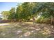 Large fenced backyard with mature trees, lush grass, and concrete pad at 12597 Cumberland Dr, Largo, FL 33773
