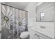 Clean bathroom with white vanity, modern fixtures, and a stylish shower curtain at 12597 Cumberland Dr, Largo, FL 33773