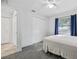 Bright bedroom features gray carpet, ceiling fan, and window with blue curtains at 12597 Cumberland Dr, Largo, FL 33773