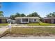 Lovely home featuring a well-kept lawn, mature trees, and neutral exterior paint at 12597 Cumberland Dr, Largo, FL 33773