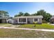 Attractive one-story home with a screened-in porch and freshly landscaped front yard at 12597 Cumberland Dr, Largo, FL 33773