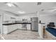 Modern kitchen featuring white cabinetry, stainless steel appliances, and a breakfast bar at 12597 Cumberland Dr, Largo, FL 33773
