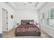 Bright bedroom featuring a large bed, side tables, and windows with plantation shutters for ample natural light at 13460 Bergamont Cir, Tampa, FL 33618