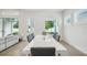 Dining room with a white table, modern chairs, and a view of the outside greenery from the windows at 13460 Bergamont Cir, Tampa, FL 33618