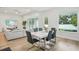 Dining room featuring a sleek white table, modern chairs, and large windows with a view of the backyard at 13460 Bergamont Cir, Tampa, FL 33618