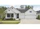 Modern farmhouse with white siding, black shutters, two car garage and solar panels on the roof at 13460 Bergamont Cir, Tampa, FL 33618