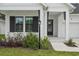Charming front entrance with a black door, black shutters and a manicured front yard at 13460 Bergamont Cir, Tampa, FL 33618