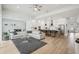 Wide view of an open-concept living room with a large sectional sofa, hardwood floors, and a modern kitchen at 13460 Bergamont Cir, Tampa, FL 33618