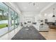 Bright living room with hardwood floors, a stylish rug, and large sliding glass doors to the outside patio at 13460 Bergamont Cir, Tampa, FL 33618