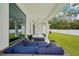 Covered outdoor patio with stylish blue cushioned seating, views of the backyard and large window at 13460 Bergamont Cir, Tampa, FL 33618
