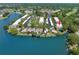 An aerial view showcasing a condo community nestled along a beautiful blue lake at 135 Nina Way # 35, Oldsmar, FL 34677