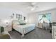 Bright bedroom with a patterned bedspread, a white ceiling fan and work area at 135 Nina Way # 35, Oldsmar, FL 34677