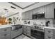 A well lit kitchen featuring stainless steel appliances, gray cabinets, and a stylish backsplash at 135 Nina Way # 35, Oldsmar, FL 34677