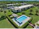 Aerial view of a pristine community pool surrounded by manicured landscaping and lounge chairs at 135 Nina Way # 35, Oldsmar, FL 34677
