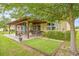 Home features an outdoor entertainment area with a covered patio and a well-maintained lawn at 13675 Paddington Way, Spring Hill, FL 34609