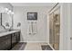 Bathroom featuring dark cabinets, granite countertops, and a glass-enclosed shower at 13675 Paddington Way, Spring Hill, FL 34609