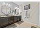 Bathroom with double vanity, granite countertops, framed mirrors and neutral paint at 13675 Paddington Way, Spring Hill, FL 34609