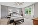 Bright bedroom with a gray accent wall, ceiling fan, carpeted floor and plenty of natural light at 13675 Paddington Way, Spring Hill, FL 34609