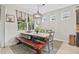 Dining area with rustic wood table and bench, designer lighting, and backyard view at 13675 Paddington Way, Spring Hill, FL 34609