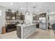 Modern kitchen featuring island with light wood accent, dark cabinets, stainless appliances, and tile floors at 13675 Paddington Way, Spring Hill, FL 34609