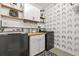 Well-organized laundry room with modern washer and dryer, built-in cabinets, and accent wall at 13675 Paddington Way, Spring Hill, FL 34609