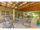 Covered outdoor living space includes ceiling fans, comfortable seating, and open backyard views at 13675 Paddington Way, Spring Hill, FL 34609