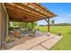 Open patio with comfortable seating, ceiling fan, grill and peaceful views of the backyard at 13675 Paddington Way, Spring Hill, FL 34609