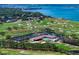 Aerial view of golf course and waterfront community, showcasing tennis courts and pool at 145 Belleview Blvd # 201, Belleair, FL 33756