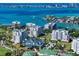 An aerial view of a condo community overlooking Sarasota Bay with other luxurious homes and clear blue water at 145 Belleview Blvd # 201, Belleair, FL 33756