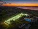 Night aerial view showing the tennis courts, pool, and golf course with ocean view at 145 Belleview Blvd # 201, Belleair, FL 33756