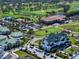 Aerial view of a golf course community featuring lush greens, a clubhouse, and well-manicured landscaping at 145 Belleview Blvd # 201, Belleair, FL 33756