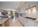 Kitchen with white cabinets, stainless steel appliances, and an island sink that opens to the dining area at 145 Belleview Blvd # 201, Belleair, FL 33756