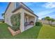 Cozy covered patio with seating and grill, surrounded by lush greenery in the serene backyard at 1476 Fort Cobb Ter, Wesley Chapel, FL 33543