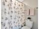 Cozy bathroom featuring a shower with floral curtain, white toilet, and soft pink towels at 1476 Fort Cobb Ter, Wesley Chapel, FL 33543