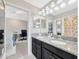 Modern bathroom featuring dual vanity sinks, granite counters, stylish lighting, and a tiled floor at 1476 Fort Cobb Ter, Wesley Chapel, FL 33543