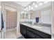 Bathroom featuring a dual sink vanity with granite counters and a separate shower and toilet area at 1476 Fort Cobb Ter, Wesley Chapel, FL 33543