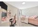 Charming bedroom featuring custom wall trim, a pink theme, and a dedicated computer space at 1476 Fort Cobb Ter, Wesley Chapel, FL 33543