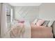 Cozy bedroom featuring custom wall trim and a pink color scheme at 1476 Fort Cobb Ter, Wesley Chapel, FL 33543