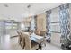Bright dining room with a large table, patterned curtains, and tile flooring at 1476 Fort Cobb Ter, Wesley Chapel, FL 33543