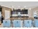 A modern kitchen featuring a large island with seating, granite countertops, stainless appliances, and stylish pendant lighting at 1476 Fort Cobb Ter, Wesley Chapel, FL 33543