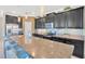 Modern kitchen featuring granite countertops, stainless steel appliances, blue backsplash, and a large island with seating at 1476 Fort Cobb Ter, Wesley Chapel, FL 33543