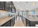 A gourmet kitchen boasts stainless steel appliances, granite countertops, tiled backsplash, and opens to the living area at 1476 Fort Cobb Ter, Wesley Chapel, FL 33543