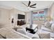 Comfortable living room with tile flooring, large windows, a ceiling fan, a sofa, and stylish decor at 1476 Fort Cobb Ter, Wesley Chapel, FL 33543