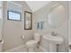 A neutral powder room with a pedestal sink, round mirror, and tiled floors at 1476 Fort Cobb Ter, Wesley Chapel, FL 33543